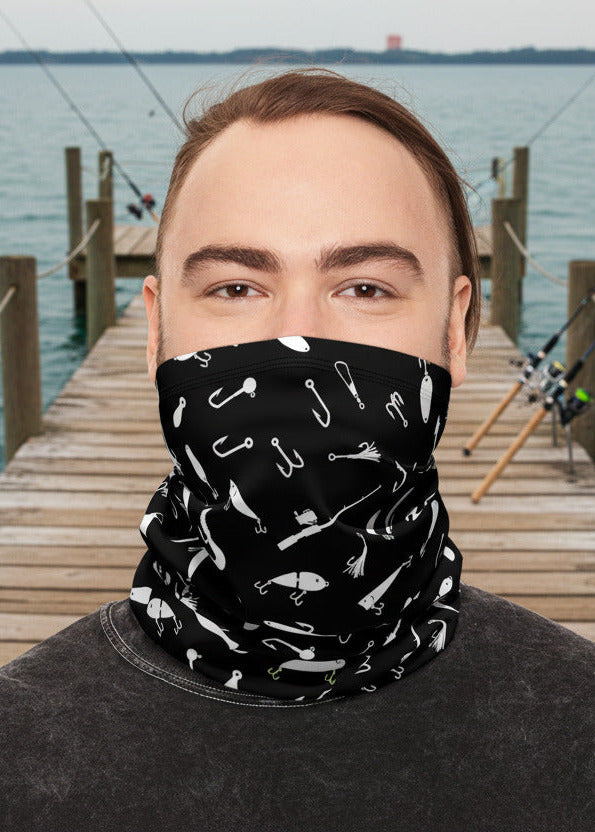 Person wearing a black patterned face mask on a dock by water