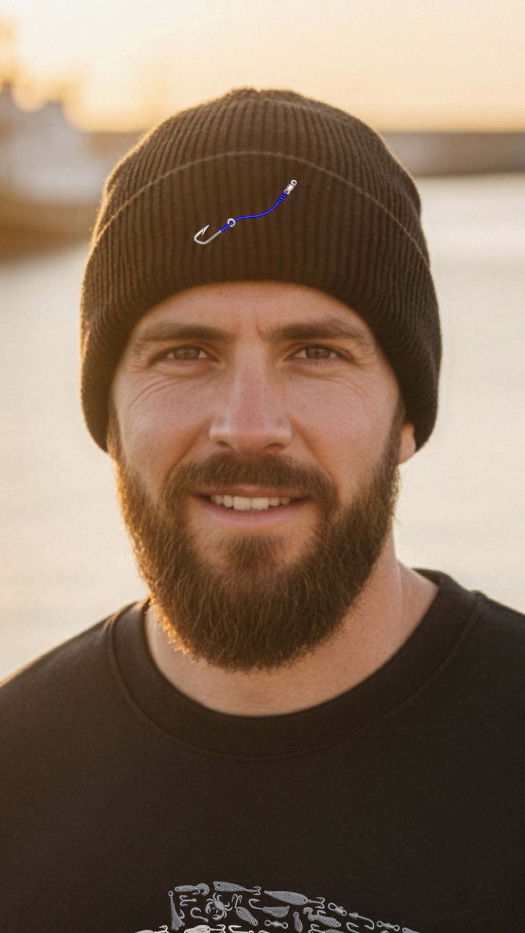 Man wearing a black beanie with a logo and a black shirt, standing outdoors.