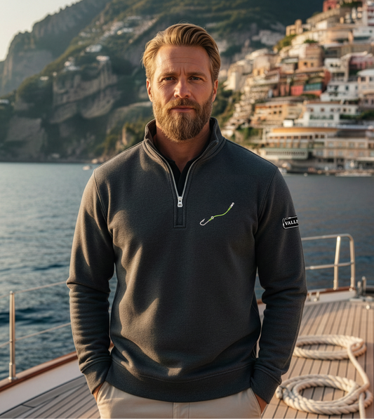 Man standing on a boat with a scenic coastal town in the background