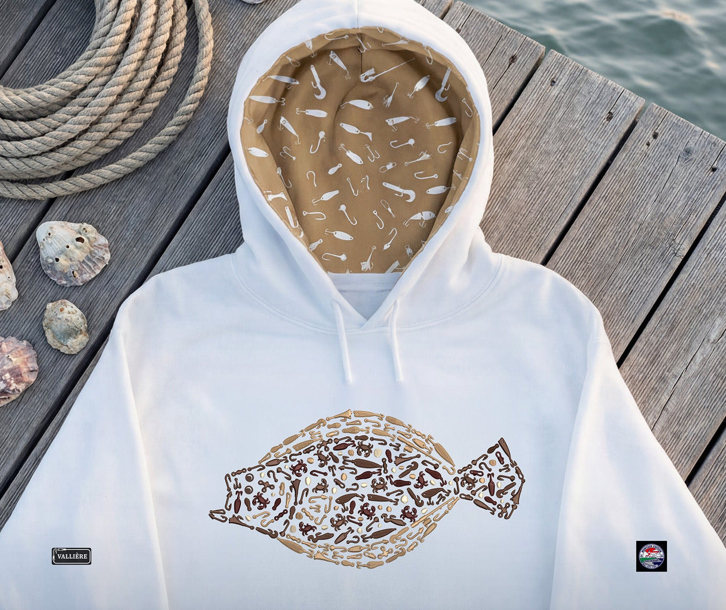 Hoodie with embroidered design on a wooden dock with rope and rocks.