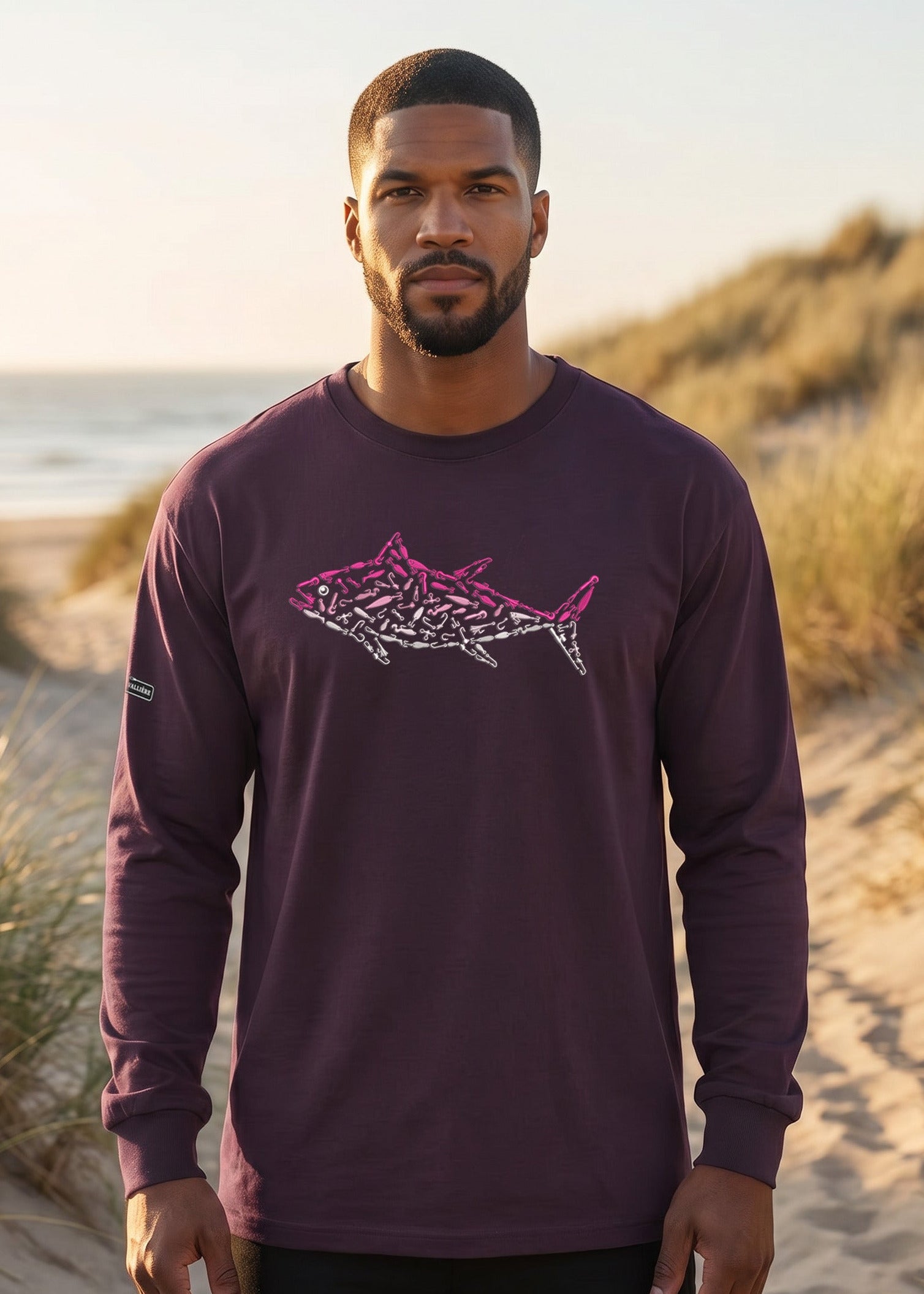 Man wearing a purple long-sleeve shirt with a shark design on a beach