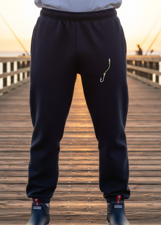 Person wearing black sweatpants on a wooden pier during sunset.
