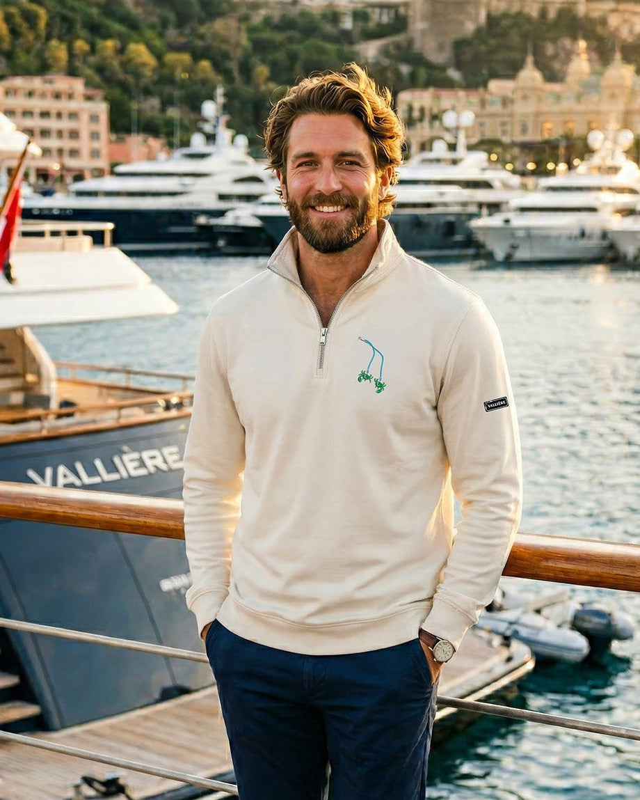 Man standing on a dock with yachts and buildings in the background