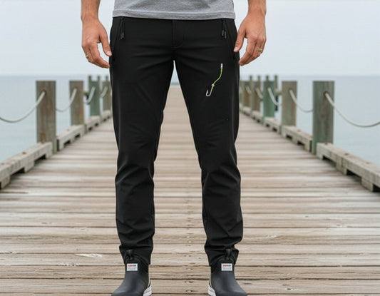 Person wearing black pants on a wooden dock with water in the background